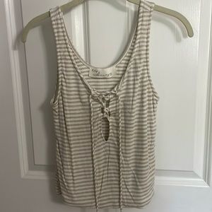 White and tan striped tank top with criss cross tie and small cutout in front